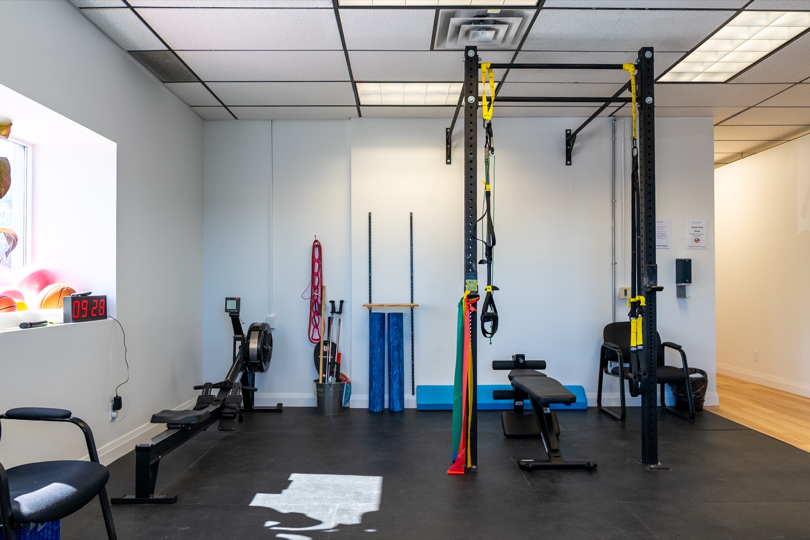 Functional training area with rowing machine, TRX rack and resistance bands