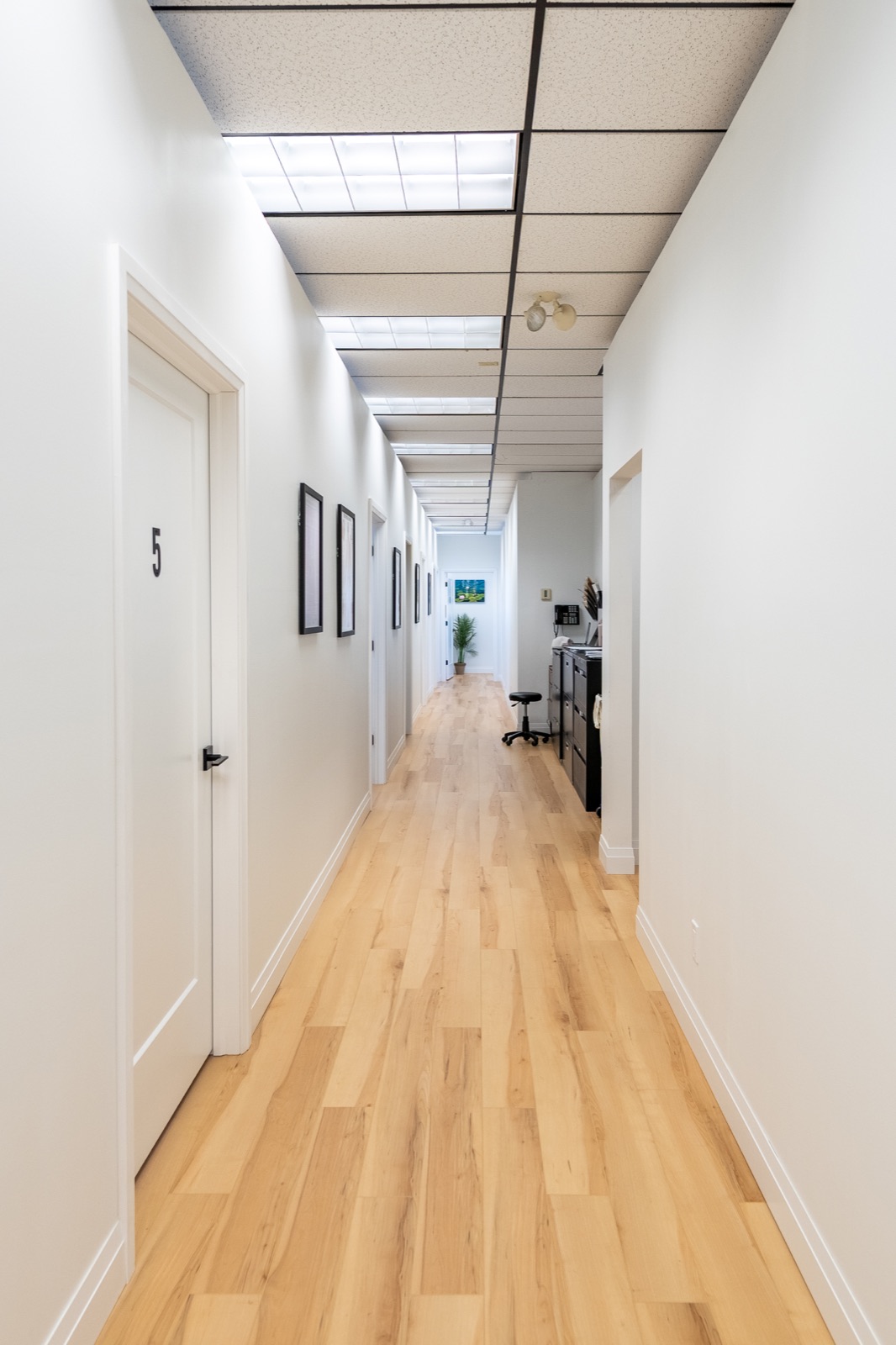 Bright hallway leading to numbered private treatment rooms